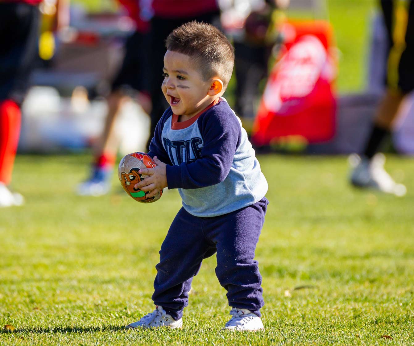 Boy holding football.