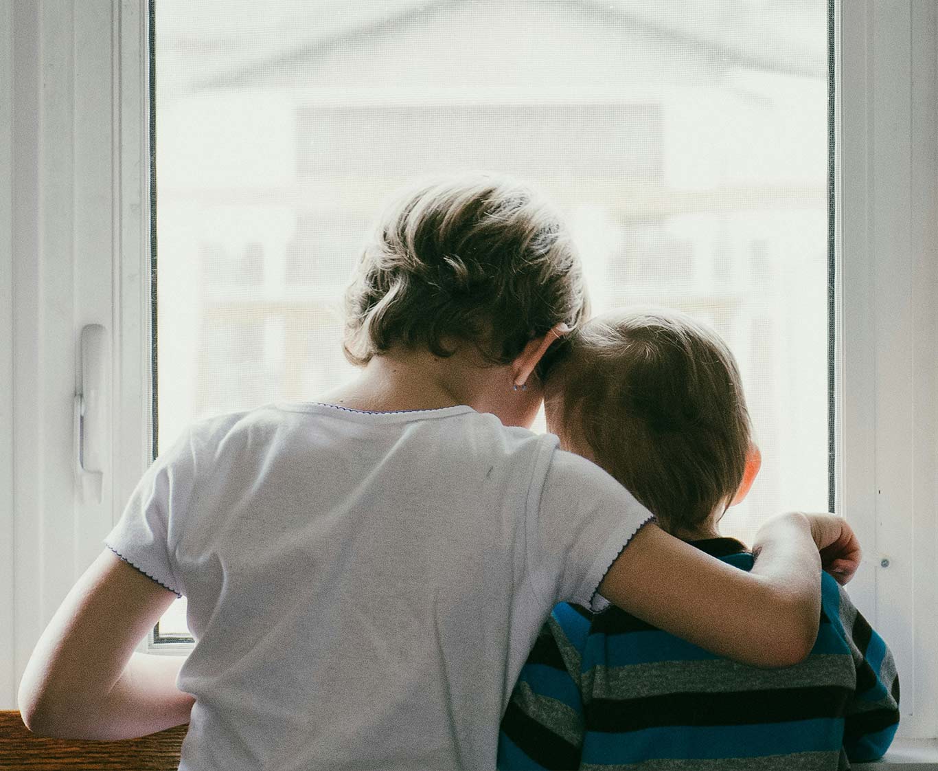 Siblings looking through the window